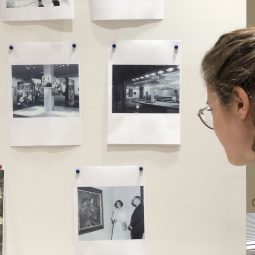 Woman looking at old photos pinned to a board